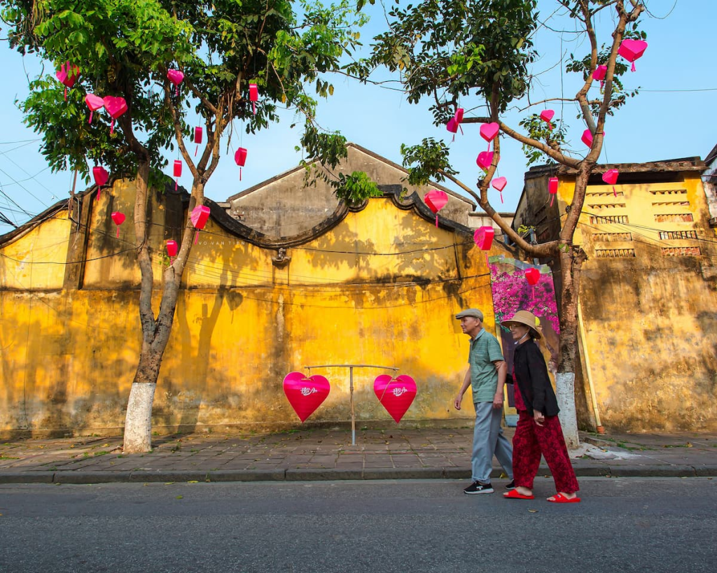 Exploring Hoi An through locals walking beside the historic yellow streets of the Ancient Town in Vietnam.