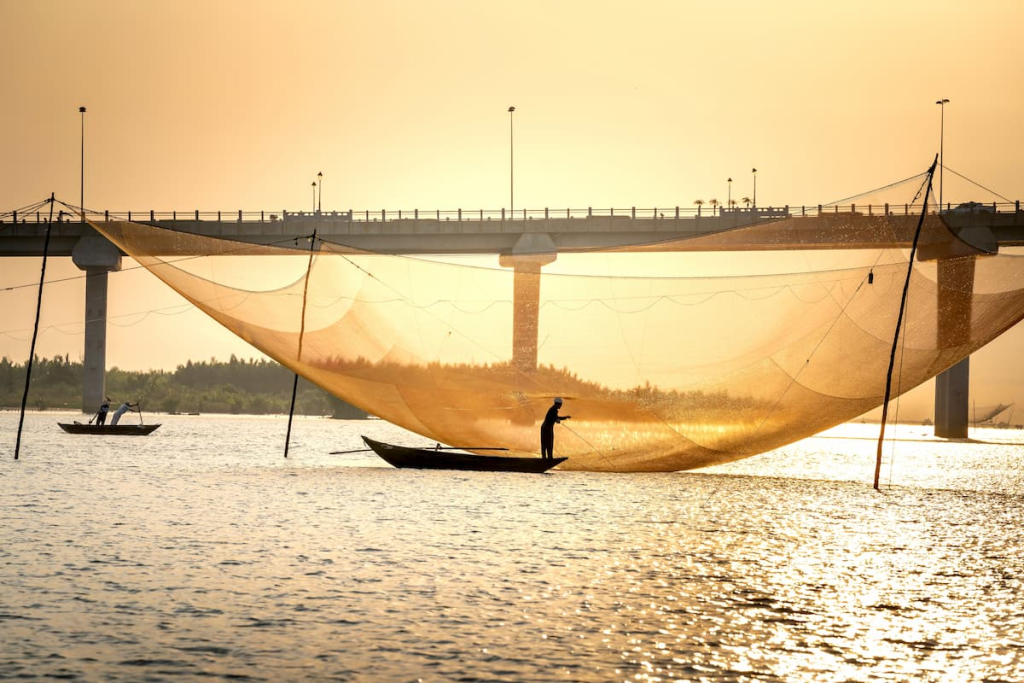Exploring Hoi An through traditional fishing on the Thu Bồn River at sunrise in Vietnam.