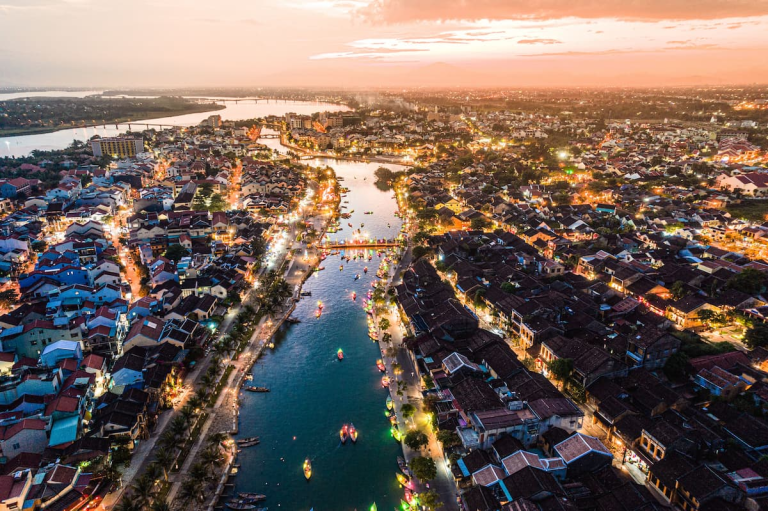 Exploring Hoi An with an aerial view of the Ancient Town and Thu Bồn River at sunset in Vietnam.
